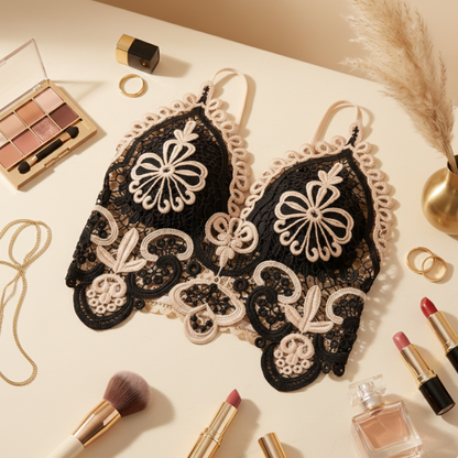 Decorative black lace bra with makeup and perfume on a light surface