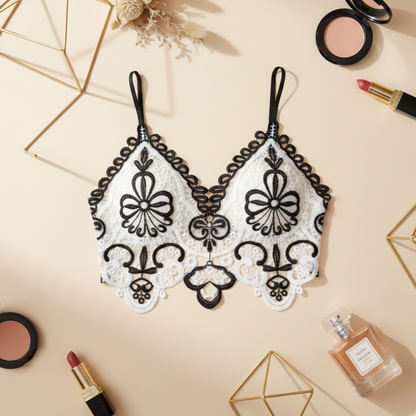 Decorative lace bralette with makeup and perfume on a beige background