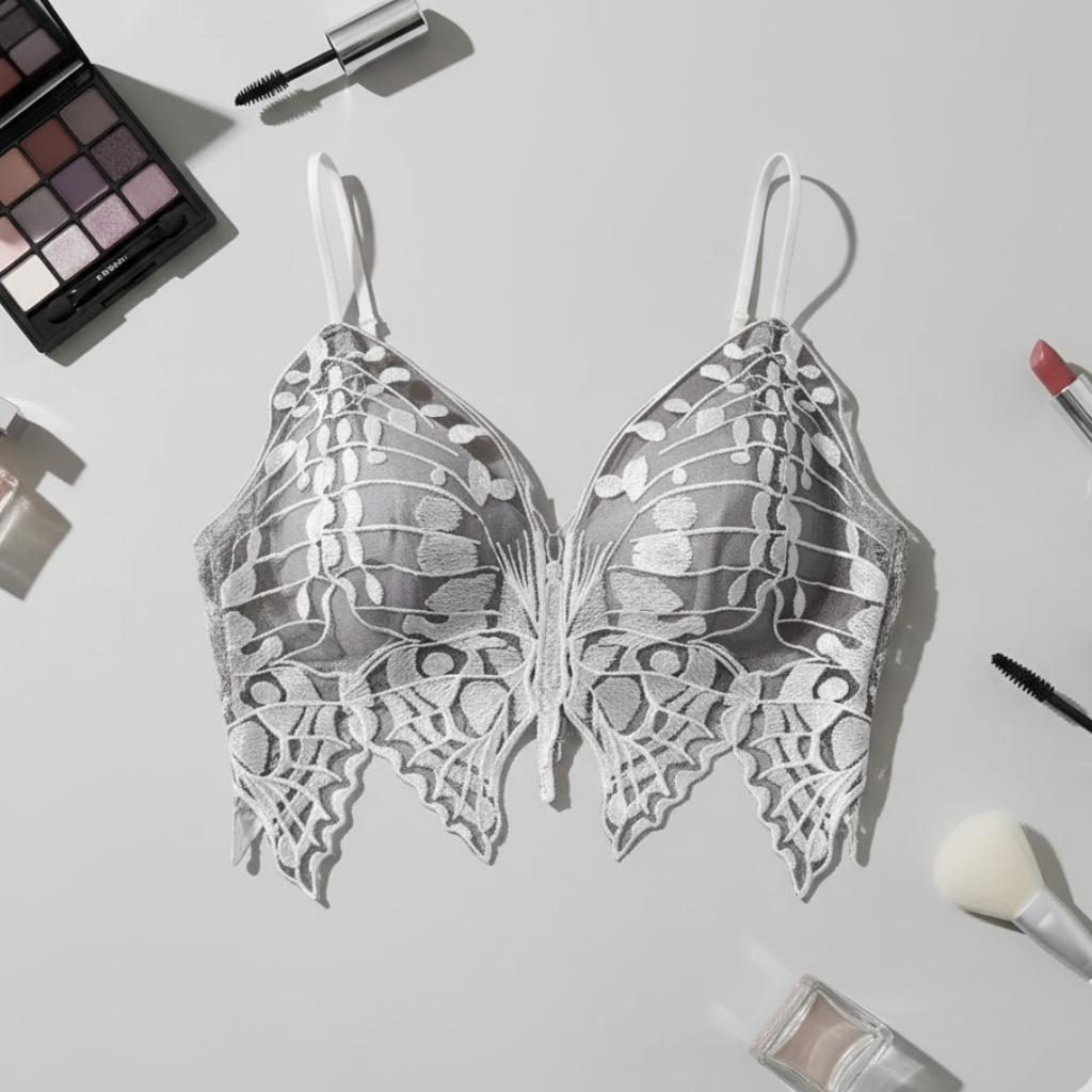 Butterfly-shaped earrings on a light gray background with makeup items.