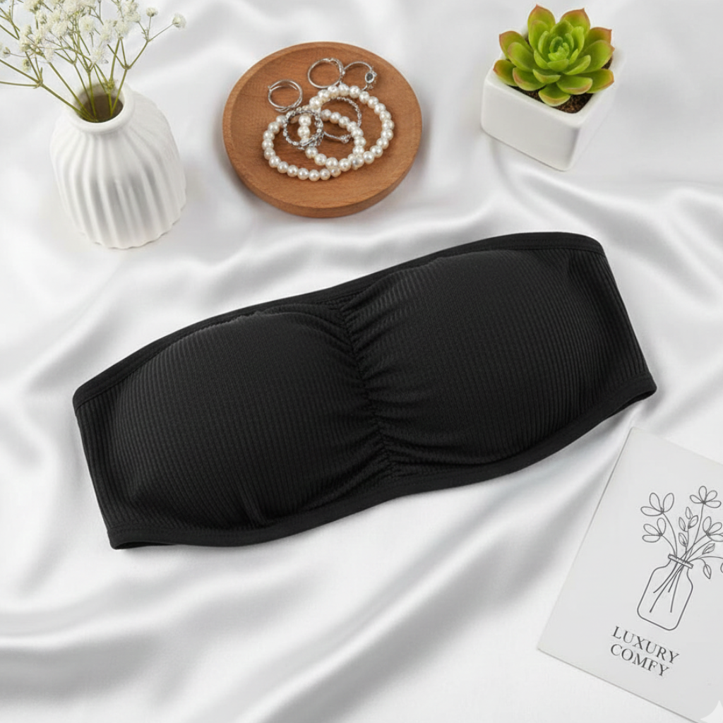 Black strapless top on a white fabric background with decorative elements.