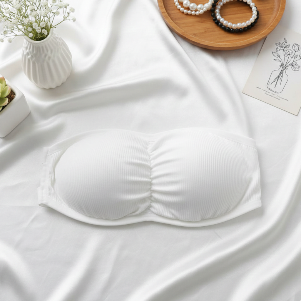 White bralette on a white fabric background with decorative items.
