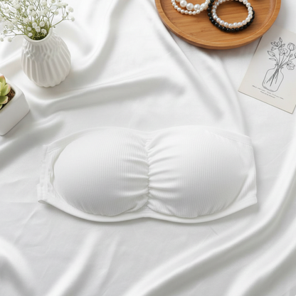 White bralette on a white fabric background with decorative items.