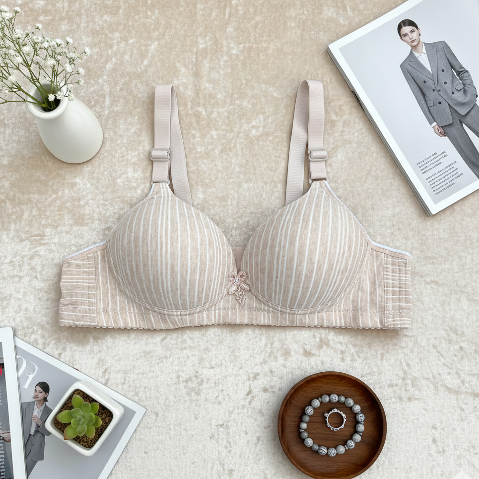 Beige bra on a textured surface with magazines and a vase in the background