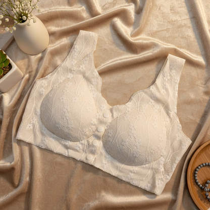 White lace bra on a beige fabric background with decorative items.