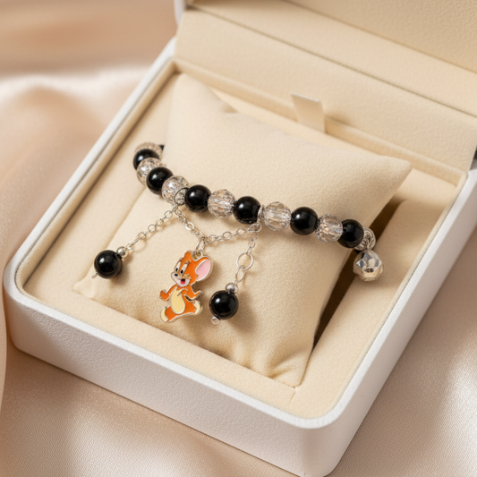 Bracelet with black beads and a charm in an open jewelry box on a light background