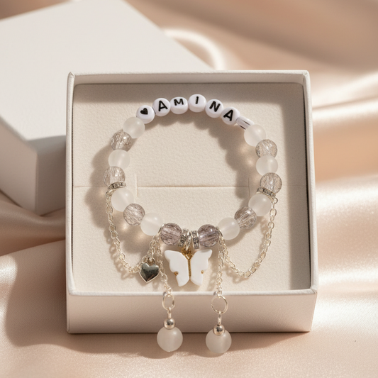 Bracelet with name beads in a white box on a soft pink background