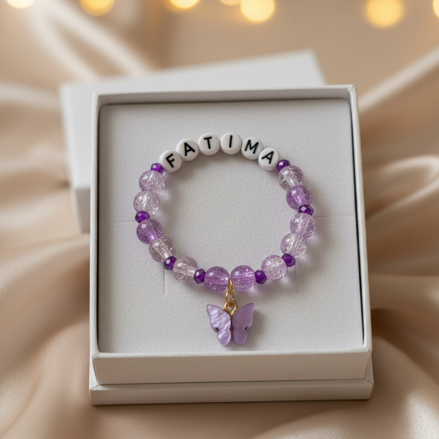 Purple beaded bracelet with 'FATIMA' on a white box against a soft background