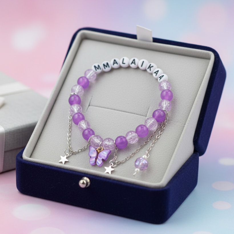 Purple beaded bracelet with 'Malaika' charm in a jewelry box on a soft, multicolored background