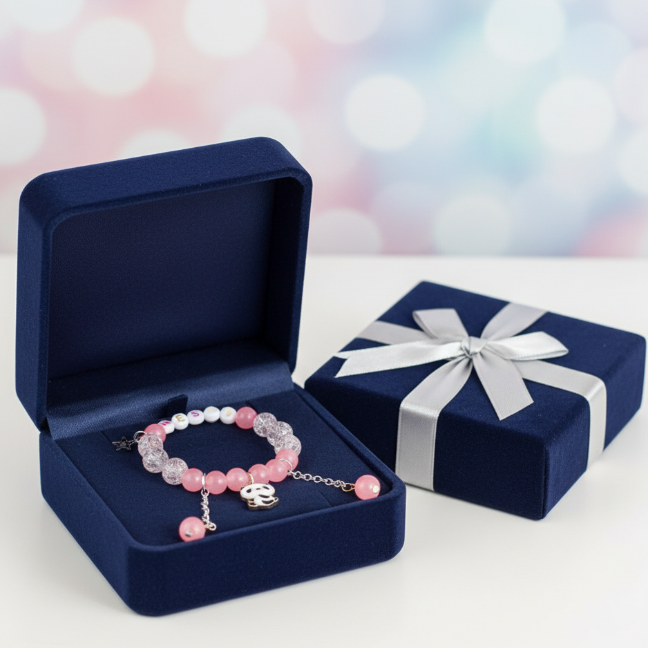 Pink beaded bracelet in an open navy blue jewelry box with a closed matching box in the background.