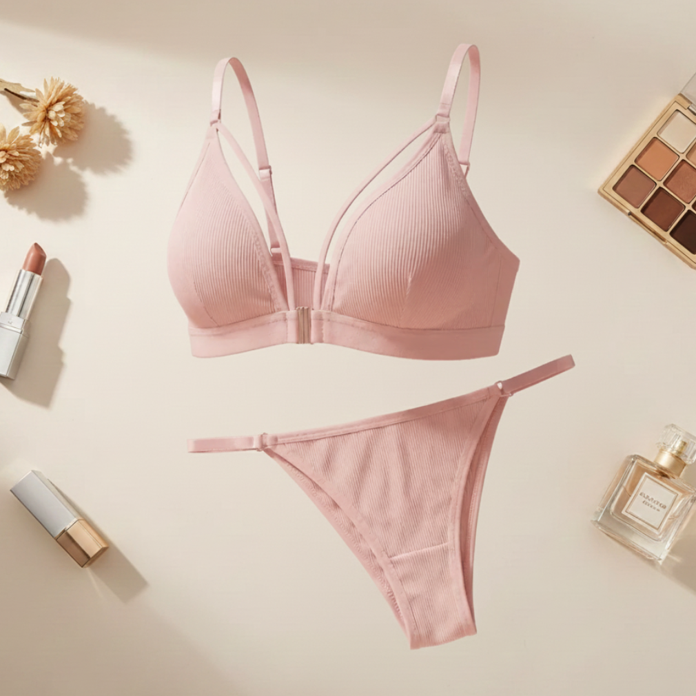Pink bra and panties set on a light beige background with makeup items.